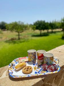 a tray with two mugs and some food on a table at B&B Le Balate in Augusta