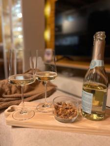 a bottle of wine and two glasses on a cutting board at Chalé Sol Nascente - Vista espetacular próximo as melhores praias de Floripa in Florianópolis