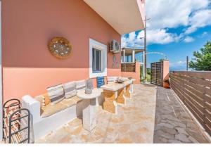 a patio with a couch and a table and chairs at Olive Grove Deluxe apartment in Agnítsini