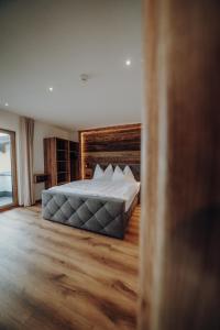 a bedroom with a bed and a wooden floor at Kleinberg Chalet in Filzmoos