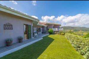 a house with a green lawn in front of it at Villa Bellavista Palau in Barrabisa