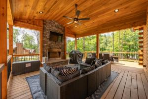 a screened in porch with a couch and a fireplace at Cabin Collina by Railey Vacations in McHenry