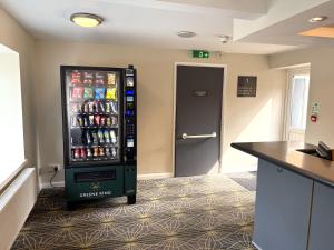 a soda machine in a kitchen with a door at The Bowman by Greene King Inns in Nottingham