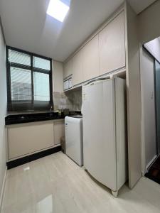 a kitchen with white cabinets and a refrigerator at B-54-Central com Wi-Fi e Ventilador, Sem Garagem in Londrina