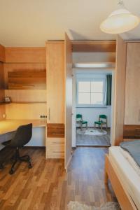 a bedroom with a bed and a desk and a chair at Ferienhaus am Wildbachberg - Platz für die ganze Familie in Deutschlandsberg