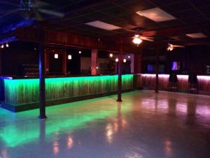 an empty dance floor in a room with green lights at Gators Inn on the Bayou in Larose