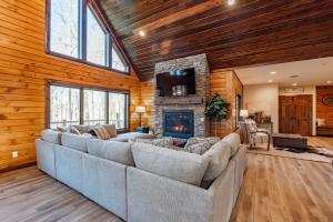 a living room with a large couch and a fireplace at Cabin Collina by Railey Vacations in McHenry