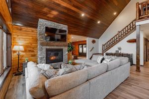 a living room with a large couch and a fireplace at Cabin Collina by Railey Vacations in McHenry +49 photos