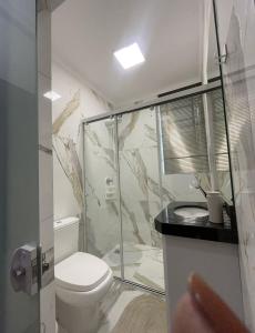 a bathroom with a toilet and a glass shower at B-54-Central com Wi-Fi e Ventilador, Sem Garagem in Londrina +18 photos
