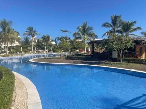 a large blue swimming pool with palm trees in the background at Villa - Sleeps 2 - Pool - Parking in Salalah