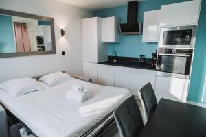 a small kitchen with a table and a white table and chairs at LE PUNTA CANA in Villeurbanne