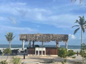 a hut on the beach with palm trees and the ocean at Villa - Sleeps 2 - Pool - Parking in Salalah