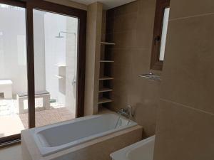 a bathroom with a bath tub and a sink at Villa - Sleeps 2 - Pool - Parking in Salalah +9 photos