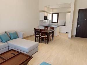 a living room with a couch and a table and a kitchen at Villa - Sleeps 2 - Pool - Parking in Salalah