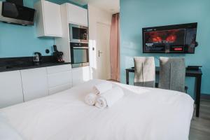 a white bed in a kitchen with towels on it at LE PUNTA CANA in Villeurbanne