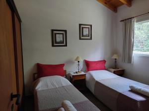 two beds in a room with red pillows at Cabañas Rincon Verde in Merlo +60 photos