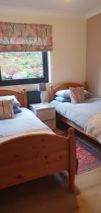 a bedroom with two beds and a window at Carrick Chalets in Cairndow