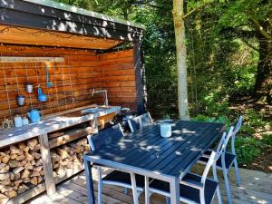 a blue table and chairs on a deck with a sink at Home Near Beach With Wilderness Bath in Sindrup