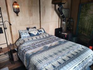 a bedroom with a bed with a comforter and pillows at Moss Haven on Hood Canal in Quilcene