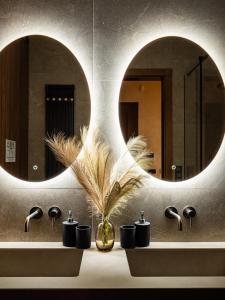 a bathroom with two sinks and two mirrors at LookTatry Tatra Stone House z Jacuzzi in Kościelisko