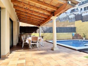 a patio with a table and chairs next to a pool at EVH105 - Casa con piscina privada in Tossa de Mar