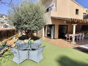 a patio with a table and chairs in a yard at EVH105 - Casa con piscina privada in Tossa de Mar
