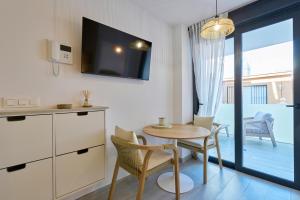 a living room with a table and chairs and a television at Sea Casa Rosa in Mijas Costa +15 photos