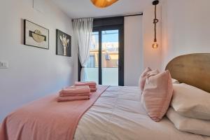 a bedroom with a bed with pink sheets and pillows at Sea Casa Rosa in Mijas Costa