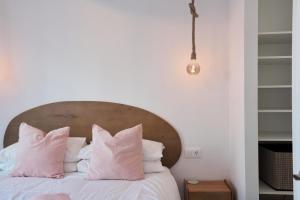 a bedroom with a bed with pink pillows at Sea Casa Rosa in Mijas Costa