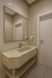 a bathroom with a large sink and a mirror at أجنحة هدوء وصول ذاتي in Medina