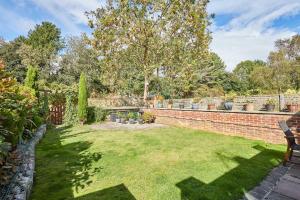 a garden with a brick wall and a bench at Host & Stay - The Station Cottage in Stanley