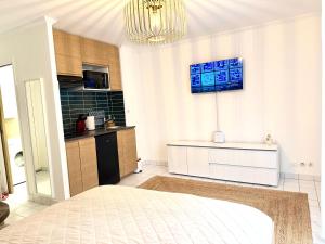 a kitchen with a bed and a chandelier at Le Matin bohème Paris- Orly- By Chozen in Épinay-sur-Orge