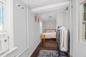 a hallway with a bed in a white room at Cozy cottage close to NYC in Yonkers