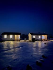 two buildings in a parking lot at night at Zacisze nad wodą in Strzegocice
