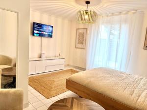 a bedroom with a bed and a tv on the wall at Le Matin bohème Paris- Orly- By Chozen in Épinay-sur-Orge