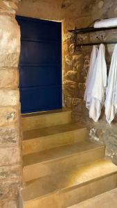 a set of stairs with a blue door and towels at לאה- וילה בוטנית LEAH- botanical villa in Safed +20 photos