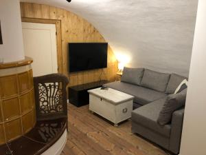 a living room with a couch and a flat screen tv at TrailHouse in Liptovský Mikuláš