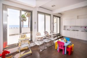 a room with chairs and tables and a kitchen with the ocean at Abruzzo Marina Hotel - Family & Beach Resort in Silvi Marina