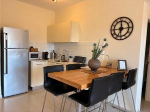 a kitchen with a wooden table and a refrigerator at ERA home boutique in Eilat
