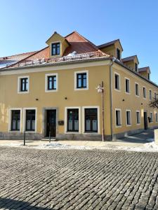 a large yellow building on a cobblestone street at Dachblick by Zirwick Apartment in Windischeschenbach