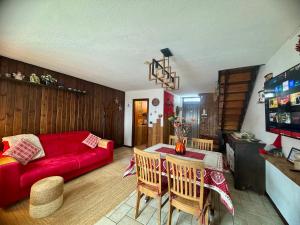 a living room with a red couch and a table at Maison au Soleil in Valtournenche