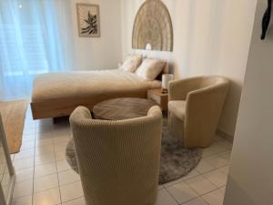 a bedroom with a bed and a table and chairs at Le Matin bohème Paris- Orly- By Chozen in Épinay-sur-Orge