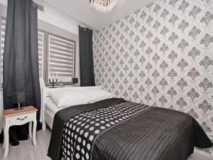 ein Schlafzimmer mit einem Bett und einer Wand in der Unterkunft Apartament Kameralny15 in Danzig