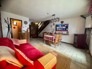 a living room with a red couch and a table at Maison au Soleil in Valtournenche +43 photos