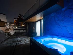 a large bathroom with a blue tub in a room at LookTatry Tatra Stone House z Jacuzzi in Kościelisko +159 photos