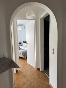a room with a bed and a hallway with an archway at Mira T1 Apartment in Carvoeiro