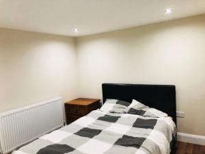 a bedroom with a black and white striped bed at Small 3 Bed Flat near Heathrow in Staines +3 photos