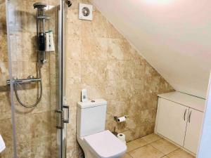 a bathroom with a shower with a toilet and a sink at Small 3 Bed Flat near Heathrow in Staines