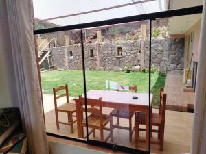 a dining room with a table and chairs and a window at Hatun Apu Center Casa de Ayahuasca y San Pedro in Pisac +37 photos