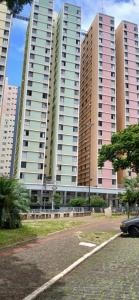 a parking lot in front of tall buildings at B-54-Central com Wi-Fi e Ventilador, Sem Garagem in Londrina